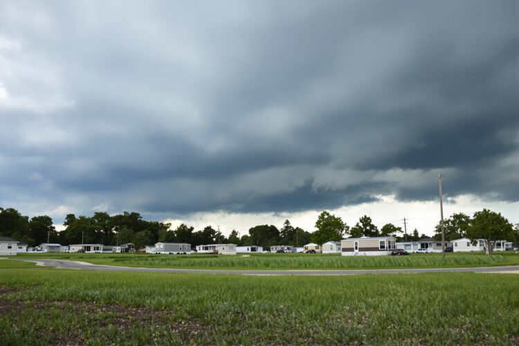 Parque de viviendas móviles en Florida bajo cielo de tormenta amenazante durante temporada de huracanes.