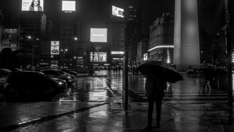 Peatones cruzan bajo la lluvia en un cruce de Tokio, Japón, durante la racha récord de precipitaciones.