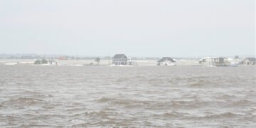 Inundaciones costeras durante una tormenta nor'easter en la costa este de Estados Unidos con olas golpeando viviendas.