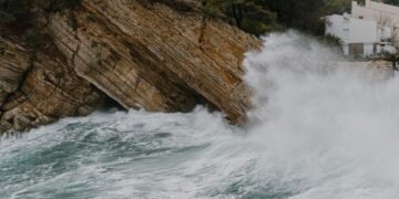 Olas gigantes y agua inundando una costa durante una tormenta del noreste en Estados Unidos.