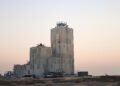Torre industrial de hormigón en China durante el atardecer, con bloques de concreto apilados.