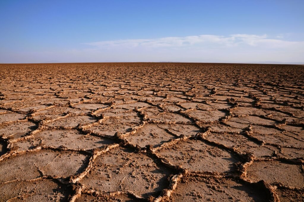 Tierra agrietada por la sequía en paisaje africano, símbolo de la vulnerabilidad climática del continente.