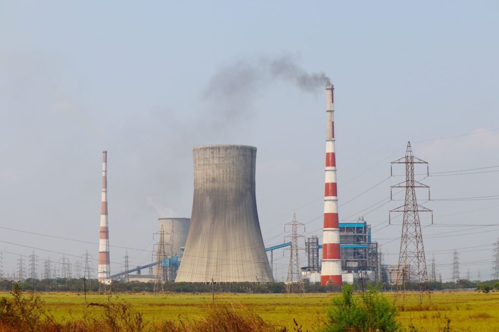 Central térmica de carbón en Asia emitiendo humo al atardecer, símbolo de la dependencia energética fósil de la región.
