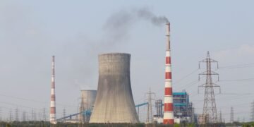Central térmica de carbón en Asia emitiendo humo al atardecer, símbolo de la dependencia energética fósil de la región.