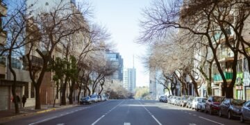 Árboles urbanos en suelo reseco durante sequía en calle de ciudad mediterránea.