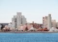 Vista de rascacielos en ciudad costera frente al océano, representando la vulnerabilidad urbana ante el aumento del nivel del