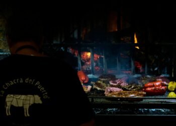 Brasas encendidas en una parrilla argentina, símbolo de la tradición del asado que un chef cuestiona por su impacto ambiental