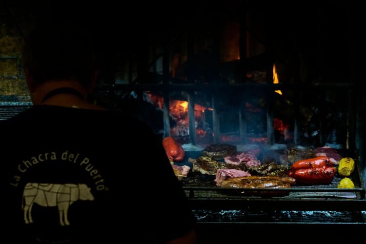 Brasas encendidas en una parrilla argentina, símbolo de la tradición del asado que un chef cuestiona por su impacto ambiental