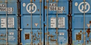 Contenedores de carga en puerto asiático al atardecer, simbolizando el comercio global de tecnología verde que China defiende