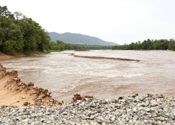 Rio crecido erosionando la ladera de una montana tras lluvias intensas en region del Himalaya.