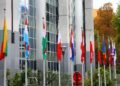 Banderas de la Unión Europea frente a edificios institucionales en Bruselas, representando las nuevas exigencias ambientales