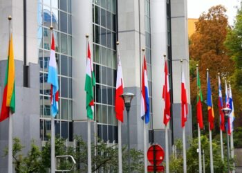 Banderas de la Unión Europea frente a edificios institucionales en Bruselas, representando las nuevas exigencias ambientales