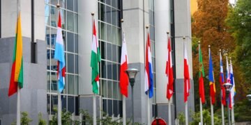 Banderas de la Unión Europea frente a edificios institucionales en Bruselas, representando las nuevas exigencias ambientales