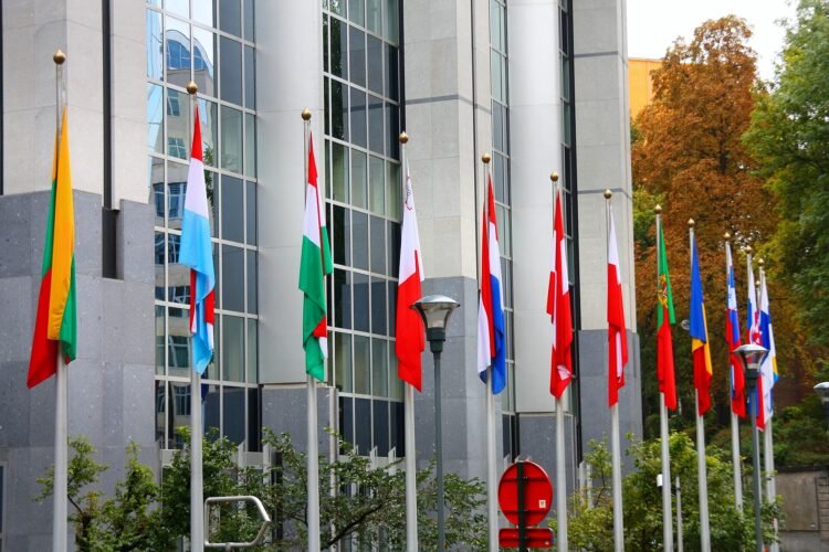 Banderas de la Unión Europea frente a edificios institucionales en Bruselas, representando las nuevas exigencias ambientales