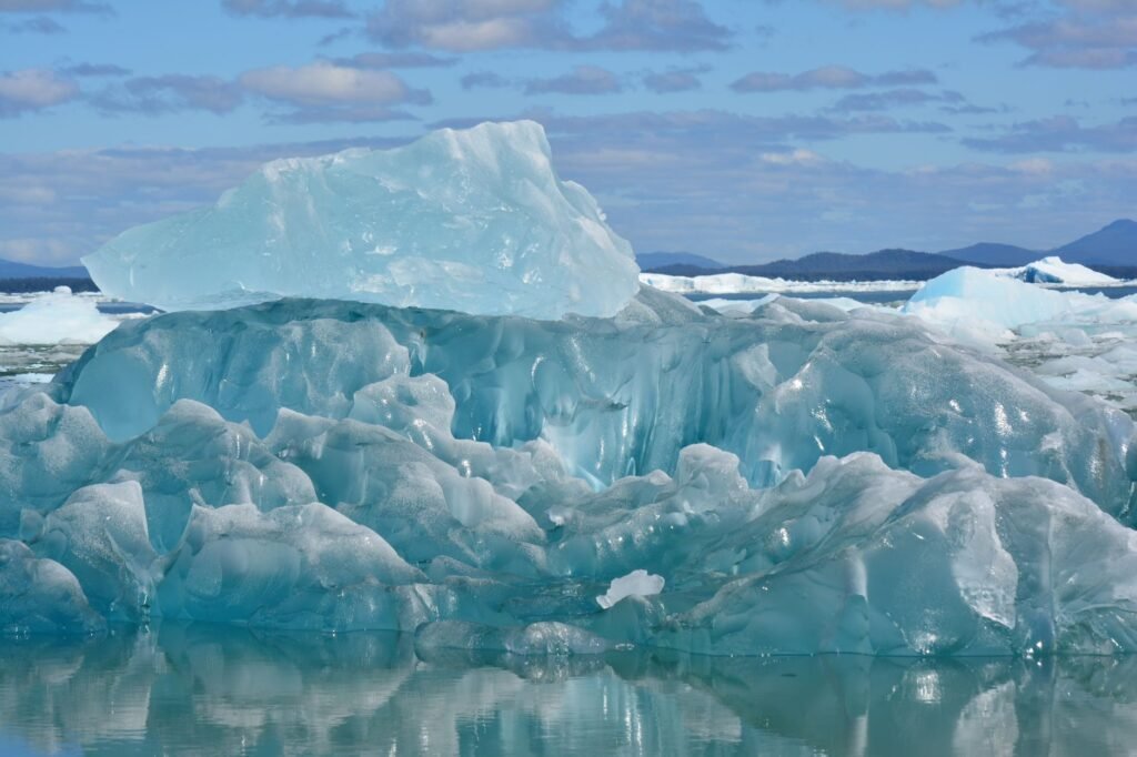 Plataforma de hielo antártico fragmentándose en el océano austral bajo el sol polar.