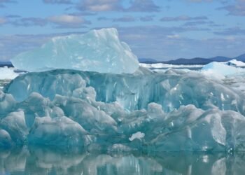 Plataforma de hielo antártico fragmentándose en el océano austral bajo el sol polar.
