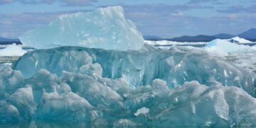 Plataforma de hielo antártico fragmentándose en el océano austral bajo el sol polar.