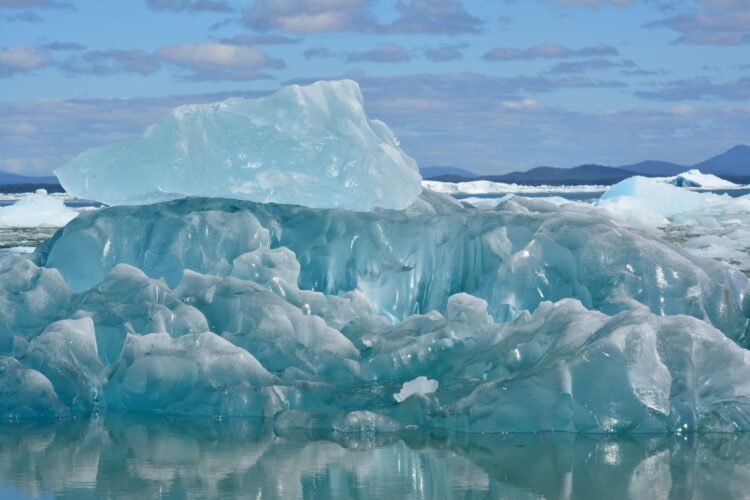 Plataforma de hielo antártico fragmentándose en el océano austral bajo el sol polar.