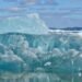 Plataforma de hielo antártico fragmentándose en el océano austral bajo el sol polar.