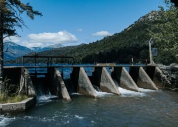 Embalse con nivel bajo de agua durante sequía, mostrando infraestructura de presa envejecida.