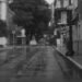 Calle inundada con vehículos bajo el agua tras lluvias torrenciales en zona urbana.