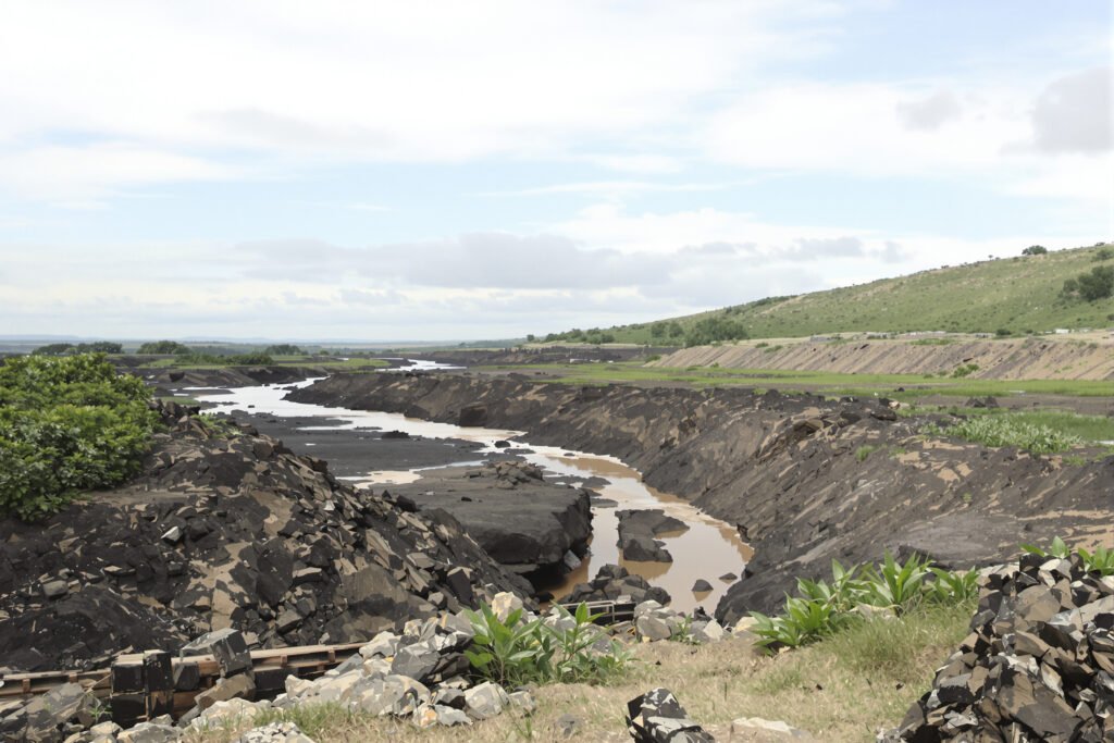 Paisaje de río en Colombia afectado por la minería de oro de aluvión, con maquinaria en las orillas.