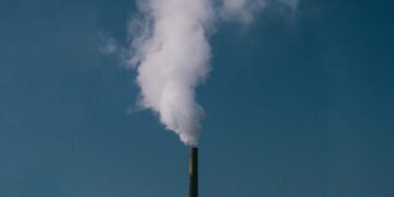 Chimeneas industriales emitiendo gases de efecto invernadero a la atmósfera.