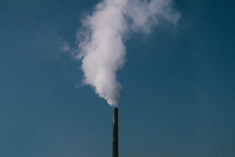 Chimeneas industriales emitiendo gases de efecto invernadero a la atmósfera.