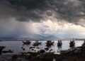 Embarcaciones pesqueras artesanales en la costa del Pacífico mexicano bajo cielo tormentoso