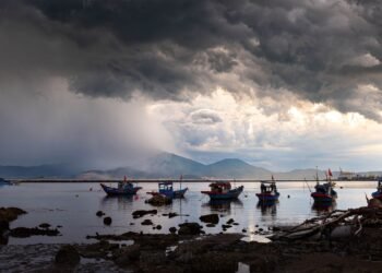 Embarcaciones pesqueras artesanales en la costa del Pacífico mexicano bajo cielo tormentoso