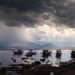Embarcaciones pesqueras artesanales en la costa del Pacífico mexicano bajo cielo tormentoso