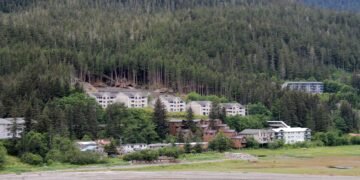 Aldea costera de Alaska devastada por tormenta, con casas destruidas y escombros dispersos sobre la tundra.